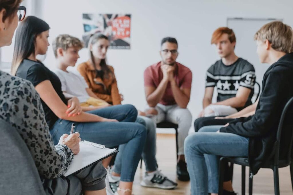 teens in a circle engage in one of the types of group therapy