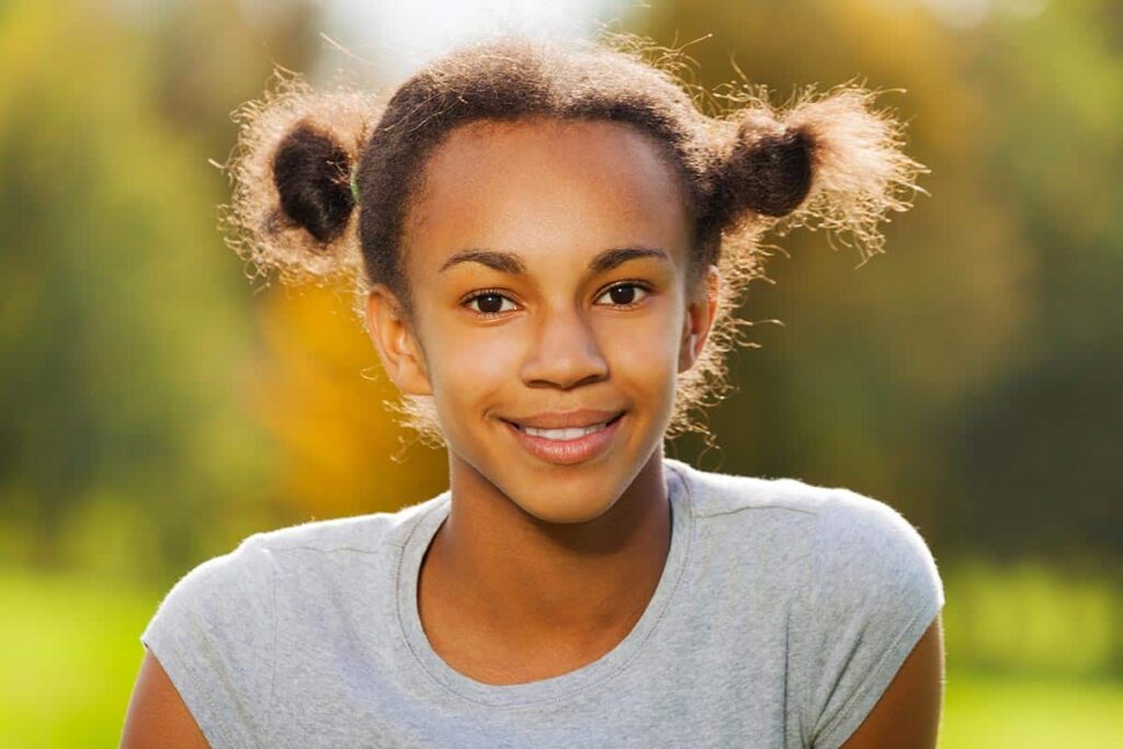 a young girl smiles at the camera while participating in therapeutic day treatment activities