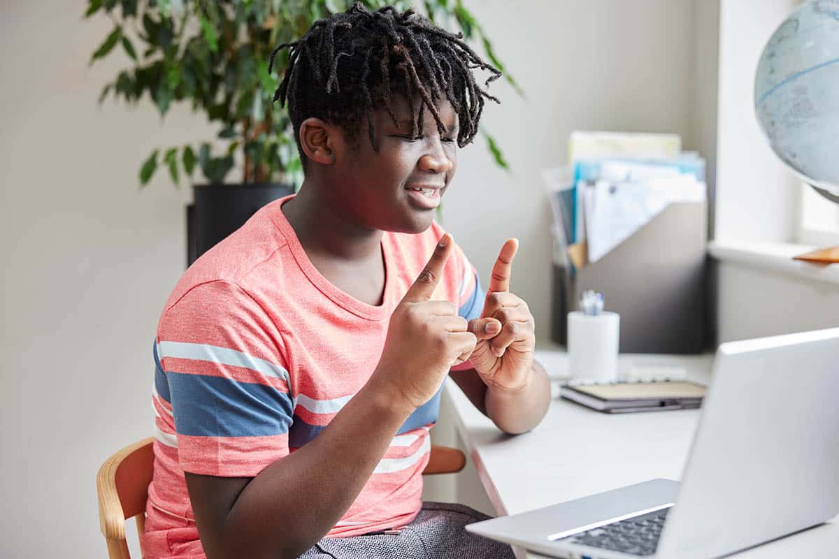 a teen motions toward a laptop during Telehealth Services