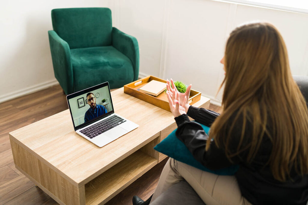 a teen meets with a virtual therapist on a computer