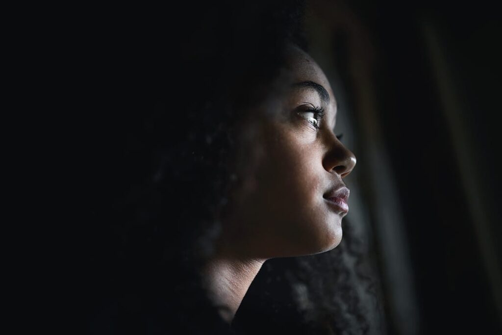 a young person looks out of a window possibly during a mental health crisis