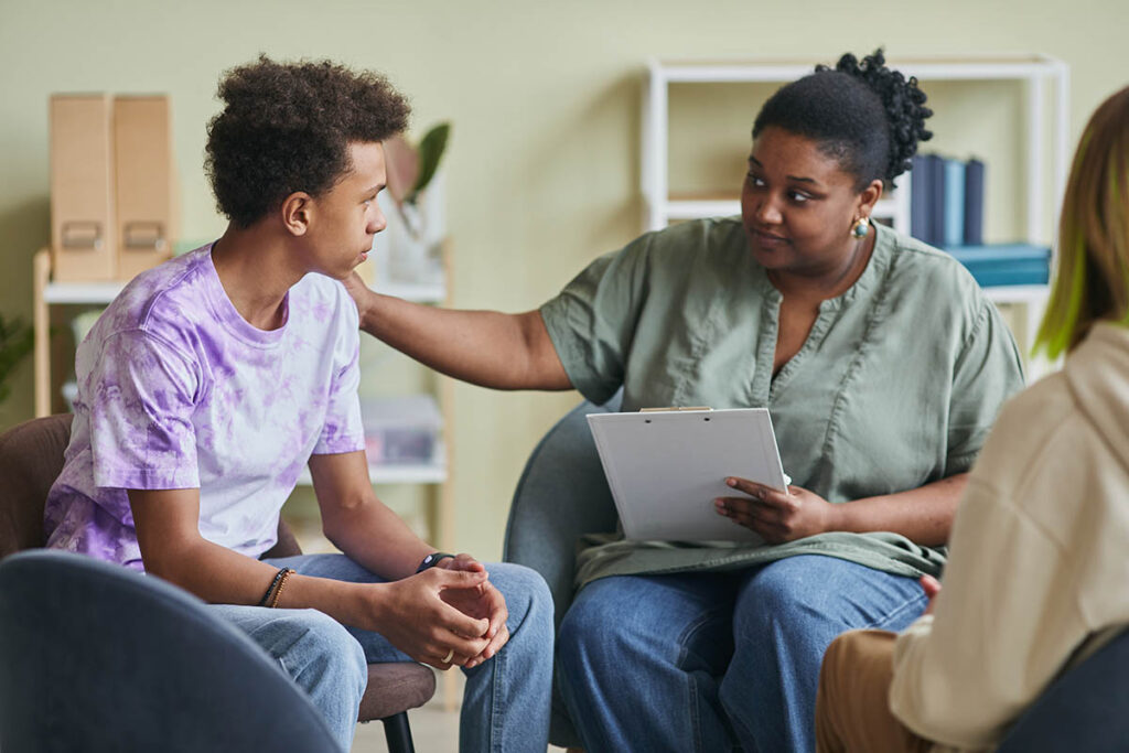 a counselor consoles a teen in a group after discussing the benefits of Individual vs Group Therapy