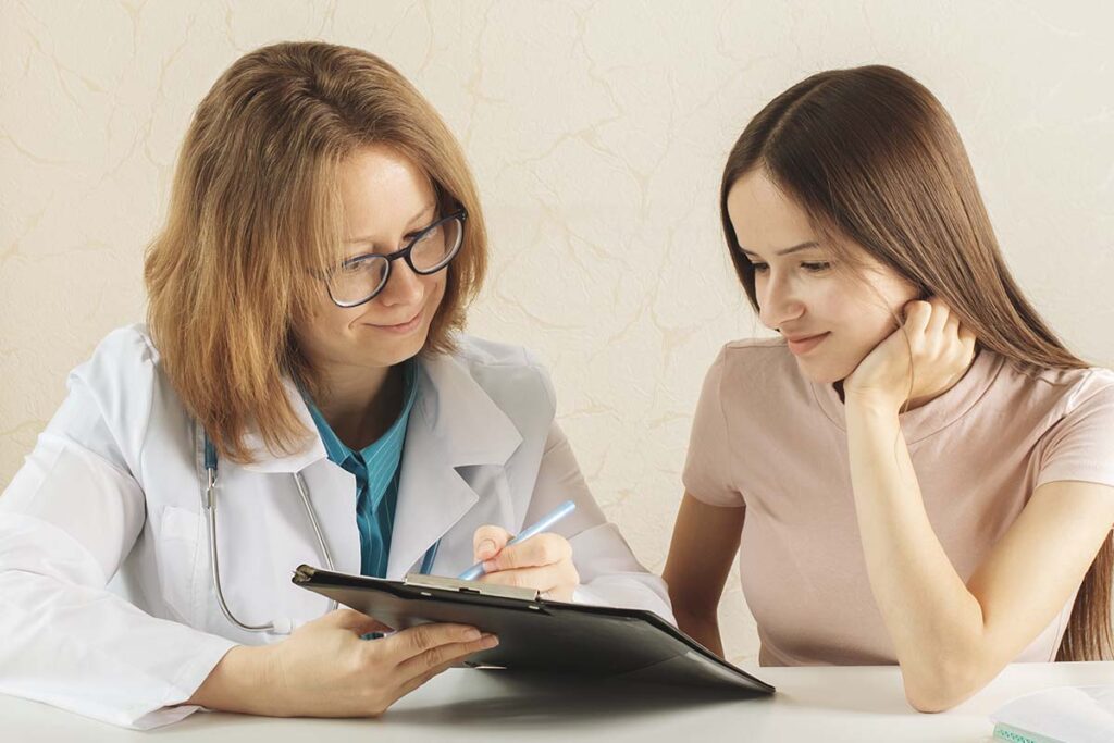 a woman talking to her doctor about what to do after inpatient treatment